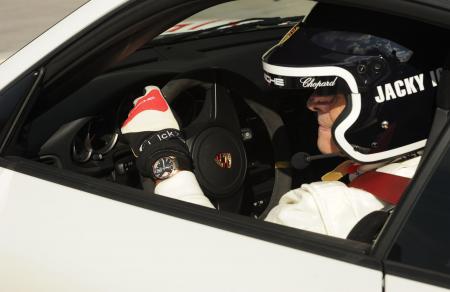 Jacky Ickx, avec le modèle Superfast Power Control, au volant d'une Porsche. 