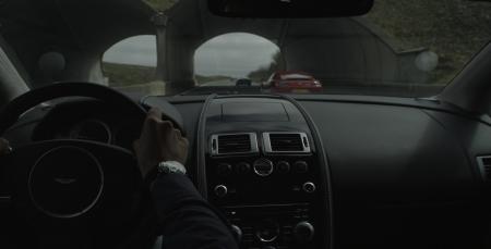 Photo de l'intérieur d'une Aston Martin et d'une Jaeger Lecoultre sur le poignet du conducteur