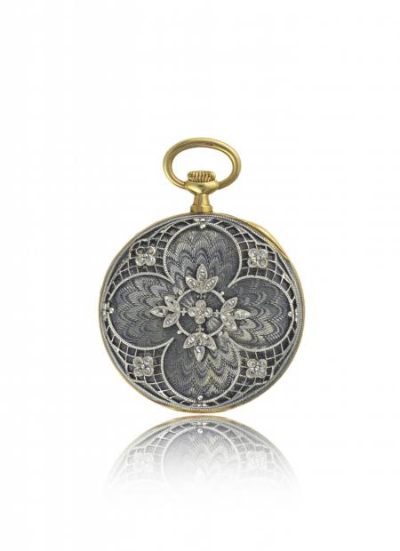 France 1909 - Montre-pendentif dame, or jaune, boîte en émail translucide sur fond guilloché, appliques décor floral platine et diamants. Cadran argenté. 